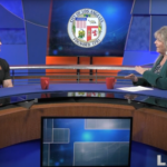 Man and woman sitting at a news desk with Los Angeles City logo in background.